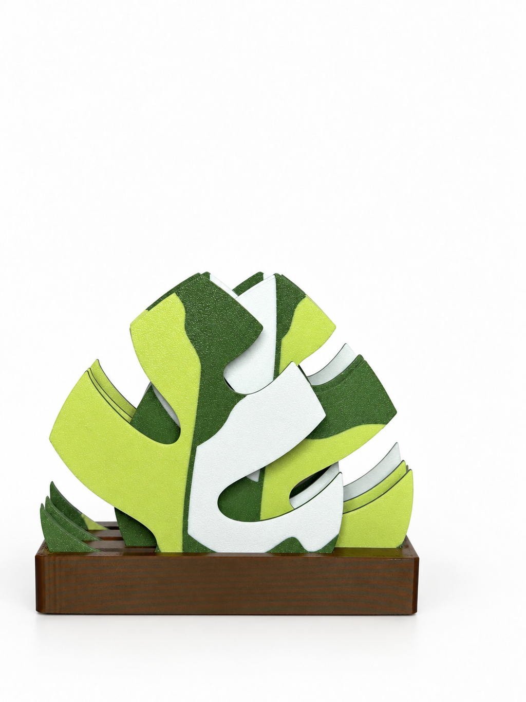 Light green, forest green and white Mini Monstera coasters in a brown staggered holder on a white background.